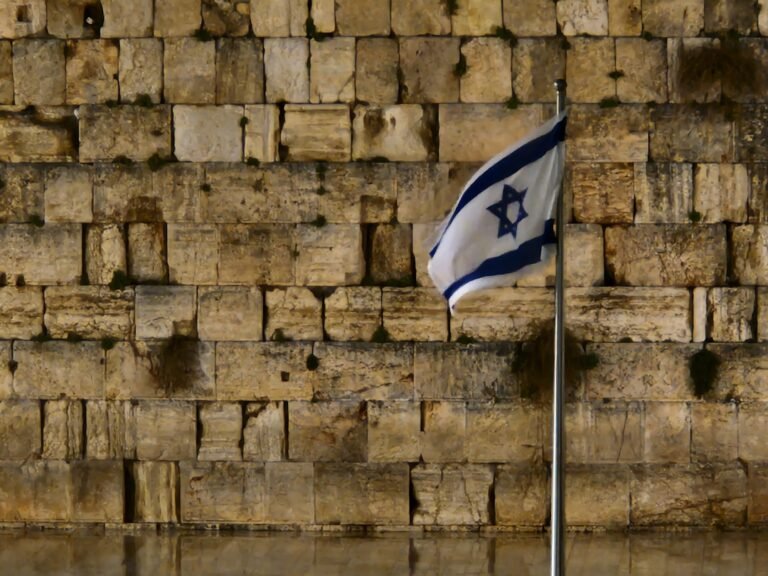 rei davi de israel - a flag is flying in front of a wall of bricks